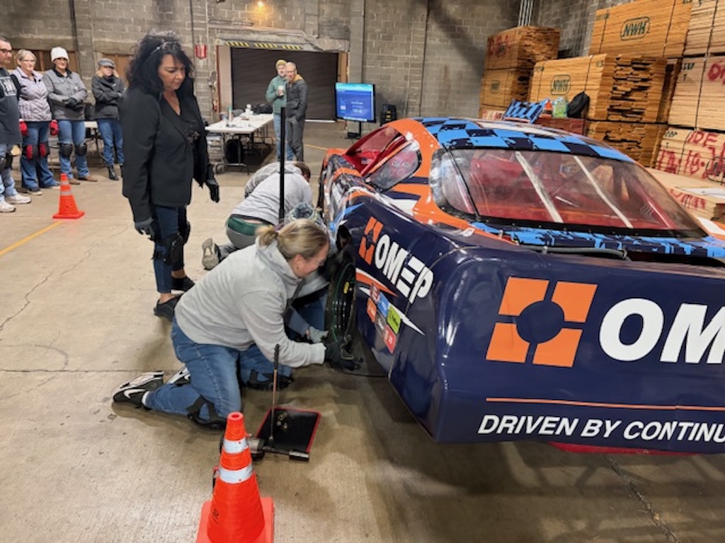 Team changing a tire during the Pit Crew Challenge team learning event