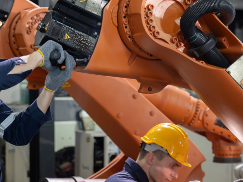 Two factory workers setting up machines